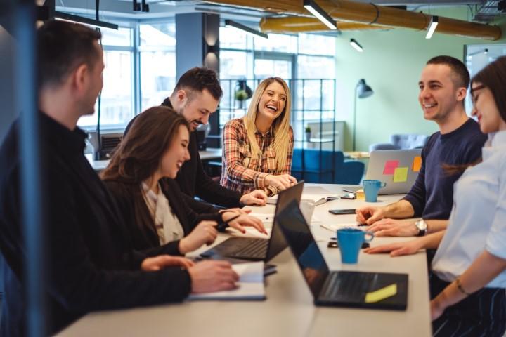 Young professionals laughing during meeting.